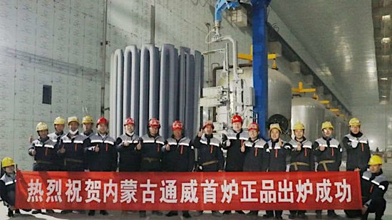 Technicians in front of polysilicon rods from the first successful run of a chemical vapor deposition (CVD) reactor in the factory of Inner Mongolia Tongwei High-Purity Polysilicon Co., Ltd. in Baotou, Inner Mongolia, China
